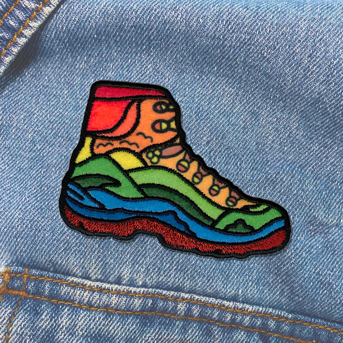 A colorful hiking boot Nature Hiking Shoe Patch on a denim jacket.