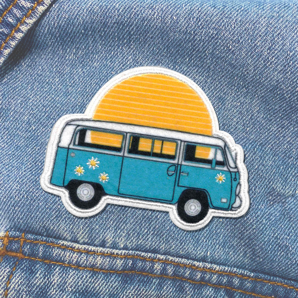 A blue KosmicSoul Sunset Bus Patch ironed on a denim jacket.