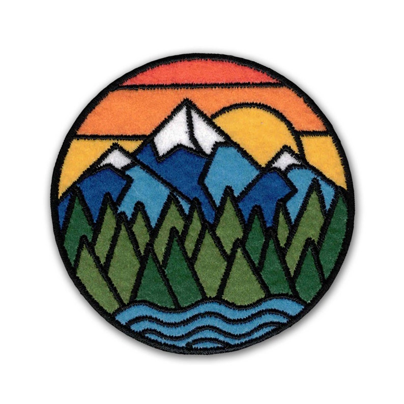 A colorful Mountain Sunset Patch sewn on with mountains and trees in the background, by KosmicSoul.